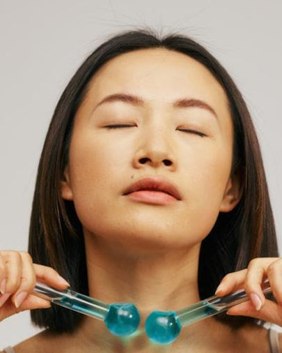 Woman using a neck massager against a plain background